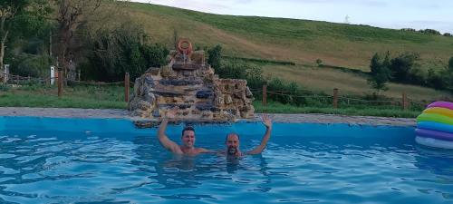 a man in a pool with a structure in the water at Glamping Quintana in Gijón