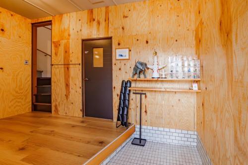 a kitchen with wooden walls and a counter with a refrigerator at HirakataBase in Hirakata