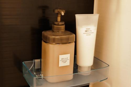 a bottle of soap and a candle on a shelf at HirakataBase in Hirakata