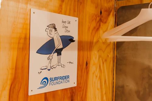 a sign on a wooden wall with a surferorgetown at HirakataBase in Hirakata