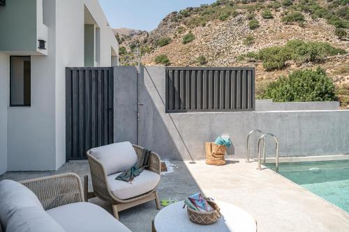 a patio with a couch and chair next to a pool at Nature's Den in Frangokastello