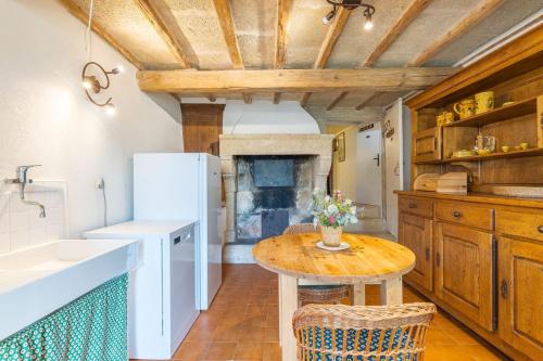 - une cuisine avec une table en bois et un évier dans l'établissement Les Calades, à Lédenon