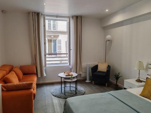 - un salon avec un lit, un canapé et une fenêtre dans l'établissement appartement champs elysees, à Paris