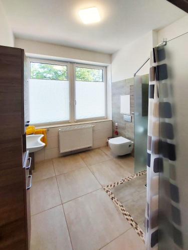 a bathroom with a sink and a toilet and a window at Wesendorf Residenz Premium Lounge in Wesendorf