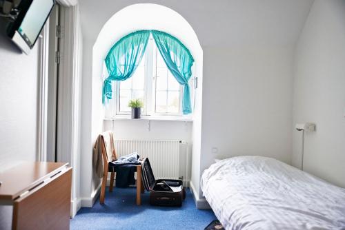 a bedroom with a bed and a window at Danhostel Odense City in Odense