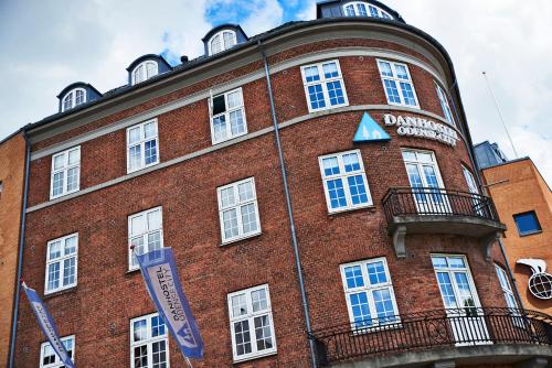 a large red brick building with a sign on it at Danhostel Odense City in Odense