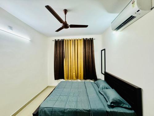 a bedroom with a bed and a ceiling fan at SERENE POND RETREAT KOWDIAR 4bhk apartment in Trivandrum