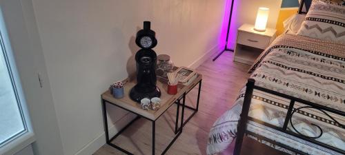 une chambre avec un lit et un réveil sur une table dans l'établissement Bêêêêl campagne - Studio nature entouré de chèvres, à Oradour-sur-Glane