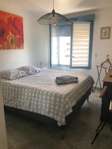 une chambre avec un grand lit avec une fenêtre dans l'établissement Appartement sur la plage, à Fos-sur-Mer