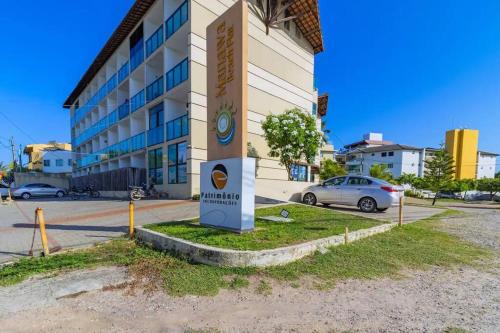 a building with a sign in front of a parking lot at Manawa Beach Flat - Porto de Galinhas in Porto De Galinhas