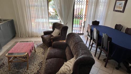 a living room with couches and a table and chairs at Bult-Op1 in Bloemfontein