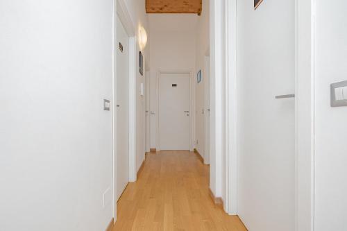 a hallway with white walls and a wooden floor at B&B Villa Milano by Rhospitality it in Cornaredo