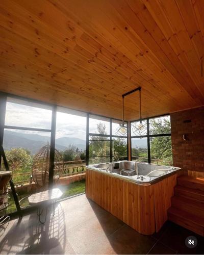 a large bathroom with a tub in a room with windows at Bujtina Kael in Librazhd