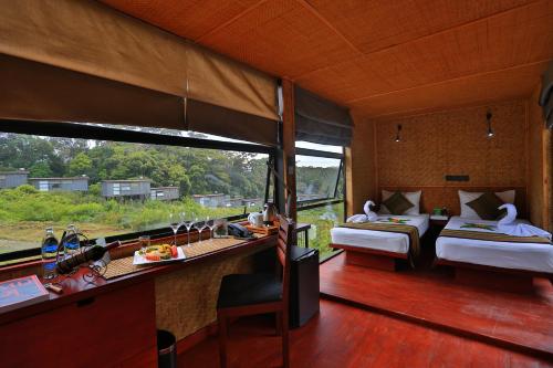 a room with two beds and a table with food at The Rainforest Ecolodge - Sinharaja in Deniyaya