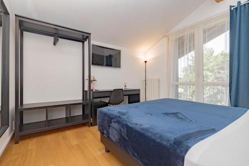 a bedroom with a bed and a desk and a window at B&B Villa Milano by Rhospitality it in Cornaredo