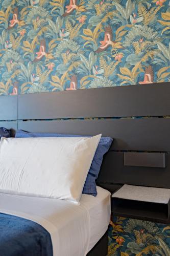 a bedroom with a bed with a floral wallpaper at B&B Villa Milano by Rhospitality it in Cornaredo
