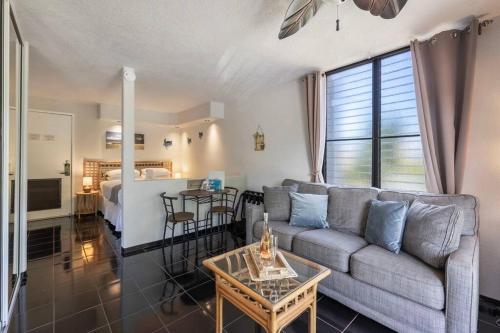a living room with a couch and a bed at Kihei Akahi C320- Kihei Studio, walk to shops, dining, & the beach in Wailea