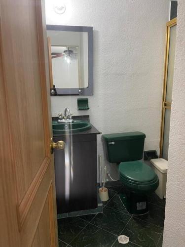 a bathroom with a green toilet and a sink at Apartamento acogedor - Melgar in Guaduala