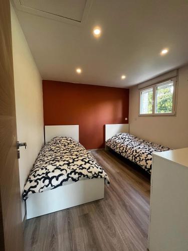 two beds in a small room with two beds at Les Gîtes des Apallus in Saint-Brisson-sur-Loire