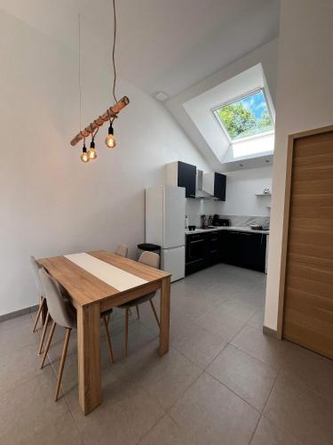 a kitchen with a wooden table and a dining room at Les Gîtes des Apallus in Saint-Brisson-sur-Loire