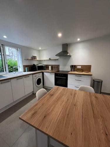 a kitchen with a wooden table and chairs in it at Les Gîtes des Apallus in Saint-Brisson-sur-Loire