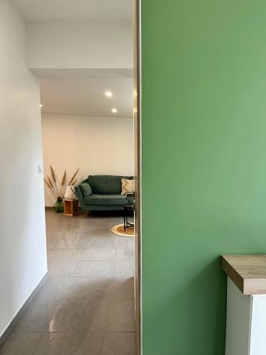 a hallway with a green couch in a living room at Les Gîtes des Apallus in Saint-Brisson-sur-Loire