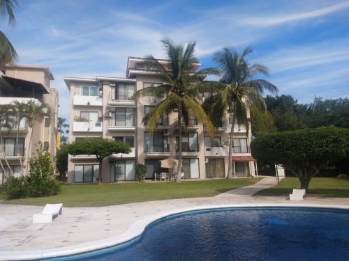 a large apartment building with a pool in front of it at Habitaciones con baño privado en Departamento compartido en Club Santiago Manzanillo in Manzanillo