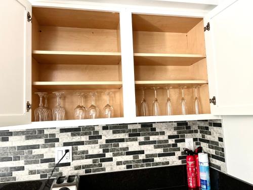 a kitchen cabinets with empty wine glasses at NEW cozy beautiful house with pool and hot tub in Fair Oaks
