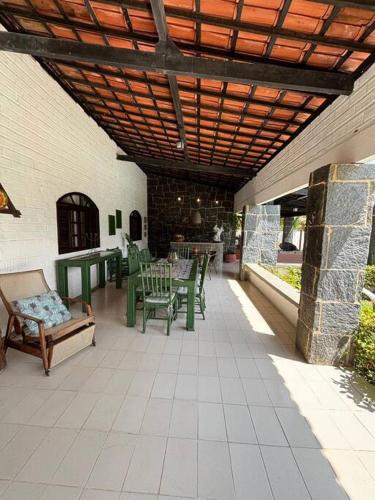 an outdoor patio with a table and chairs at Ampla casa de 3 quartos com piscina em Serrambi PE a 50mts do mar in Porto De Galinhas