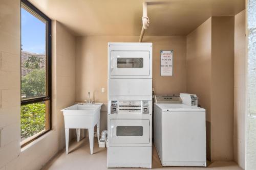 a small kitchen with a sink and a refrigerator at Maui Kai 808 · MK 808 OceanFront 1BD Kaanapali Beach Ocean Views in Lahaina
