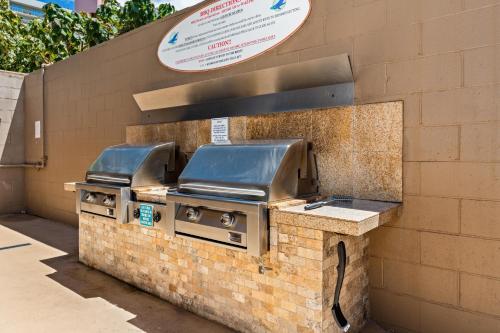 a grill on a brick wall with a sign at Maui Kai 808 · MK 808 OceanFront 1BD Kaanapali Beach Ocean Views in Lahaina