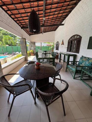 a patio with a table and chairs on a patio at Ampla casa de 3 quartos com piscina em Serrambi PE a 50mts do mar in Porto De Galinhas