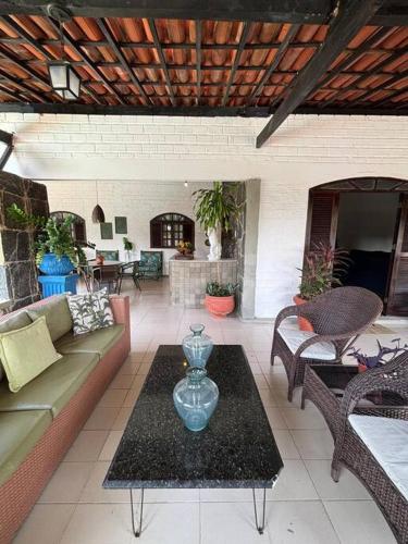 a living room with a couch and a table at Ampla casa de 3 quartos com piscina em Serrambi PE a 50mts do mar in Porto De Galinhas