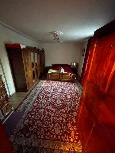 a room with a bed and a red rug at Casa Zizi in Pucioasa