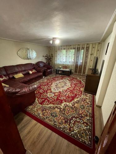 a living room with a couch and a rug at Casa Zizi in Pucioasa