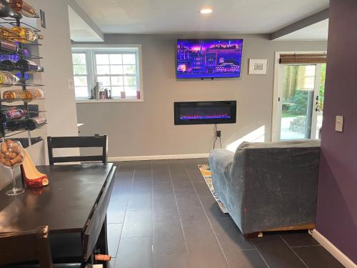 a living room with a table and a tv on the wall at Maxine Manor in Douglasville