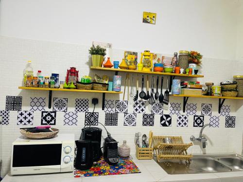 a kitchen counter with a microwave and a sink at Villa diam la paix in Guediawaye