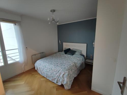 une chambre avec un lit et un mur bleu dans l'établissement Big, Newly Renovated and Bright 3 Bedroom Flat in center of Courbevoie - 89m2, à Courbevoie
