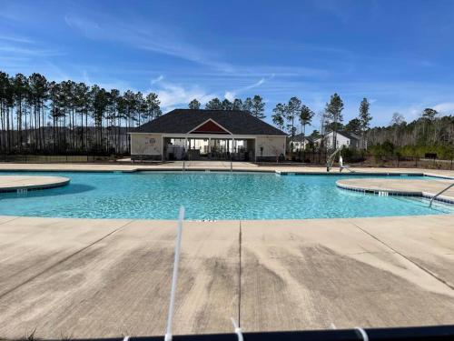 a large swimming pool with a house in the background at New Construction Smart Home in Hubert