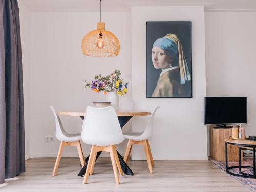 a dining room with a table and a painting of a woman at Zandvoortferienwohnungen in Zandvoort