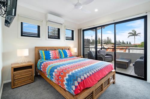 a bedroom with a bed and a view of a patio at LaBellaVita 26 Landsborough St SWR in South West Rocks