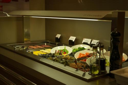 a buffet with plates of food on a table at Ibis Astana in Astana