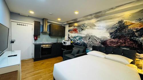 a bedroom with a white bed and a painting on the wall at Private Boutique Apartments London in London