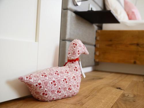 a toy chicken sitting on the floor in a kitchen at Zum Hirschen - hotel & gasthaus beim stöckeler in Scheidegg