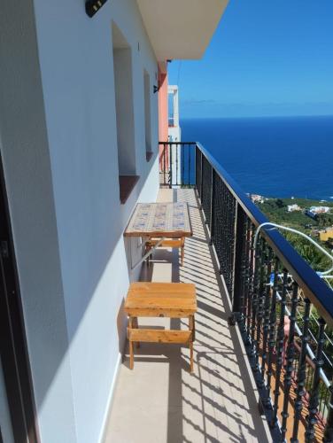a balcony with two benches and the ocean at Vivienda Los Tilos in San Andres y Sauces