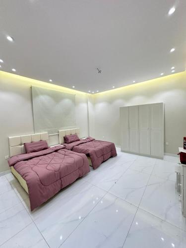 a large white room with two beds in it at شقق خلف مطار الملك عبدالعزيز in Buraymān