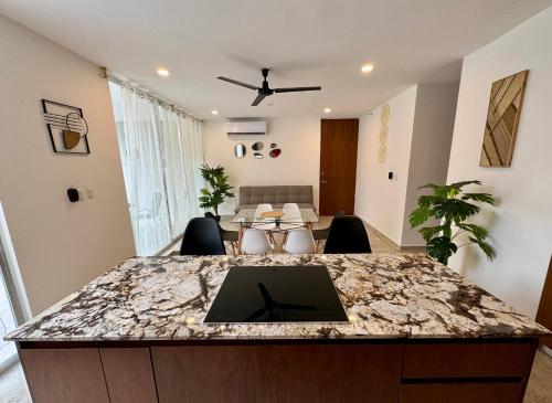 a kitchen and living room with a marble counter top at Departamento en Mérida en Privada con Amenidades in Xcanatún