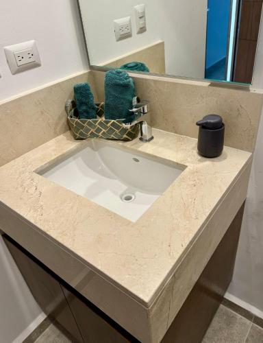 a white sink in a bathroom with a mirror at Departamento en Mérida en Privada con Amenidades in Xcanatún
