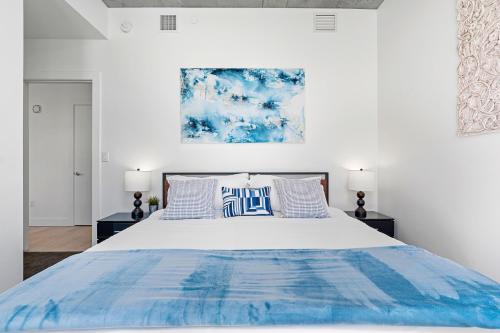 a bedroom with a large bed with blue and white pillows at City Views! Luxury King bed gym pool HTub in American Towers Condominium