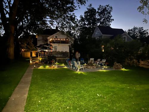 a yard with chairs and lights in the grass at 515Escape - Near downtown, private backyard, firepit, bbq, fun! in Lake Geneva